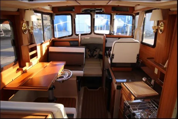Slide: The Image of Interior of 2017 Ranger Tugs R-27 boat, featuring wood finishes and seating area. - 29