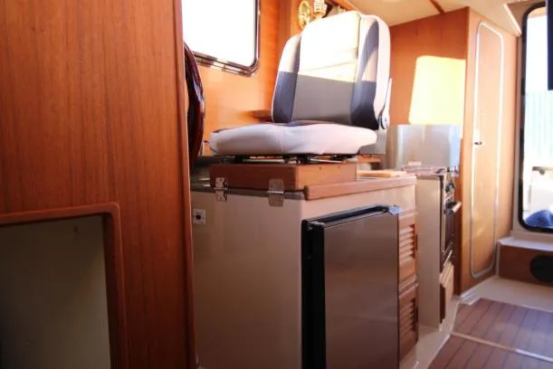 Slide: The Image of Interior of 2017 Ranger Tugs R-27 boat with seating and compact kitchen area. - 33