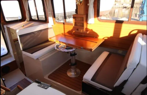 Slide: The Image of Interior of 2017 Ranger Tugs R-27 with wooden table and cushioned seating. - 36