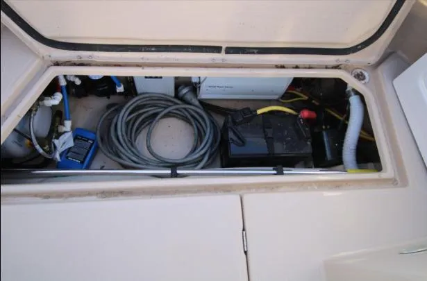 Slide: The Image of 2017 Ranger Tugs R-27 storage compartment with coiled hose and battery. - 41