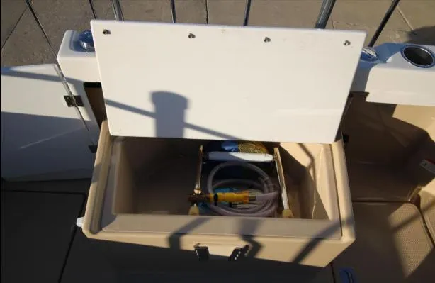 Slide: The Image of Open storage compartment on 2017 Ranger Tugs R-27 boat, containing hoses and equipment. - 43