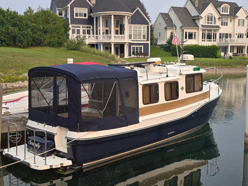 Slide: The Image of 2017 Ranger Tugs R-27 boat docked near waterfront homes. - 7
