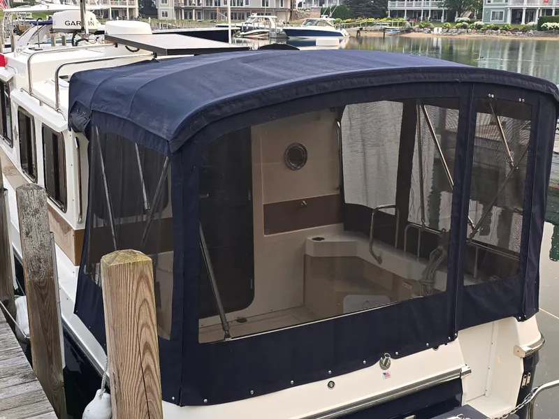Slide: The Image of 2017 Ranger Tugs R-27 boat with blue canopy docked at marina. - 8