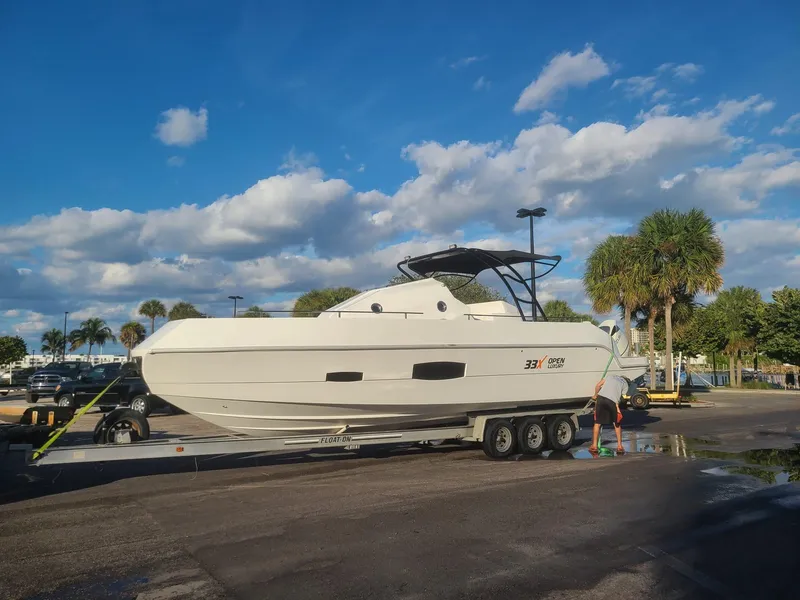 Slide: The Image of 2021 Giupex 33 boat on trailer under blue sky with palm trees. - 3