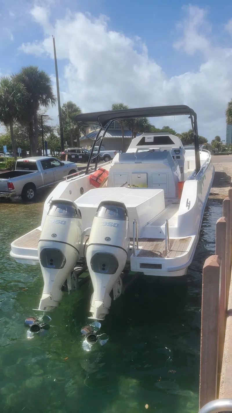 Slide: The Image of Giupex 33 boat on water, sunny day, palm trees in background, 2021 model. - 6