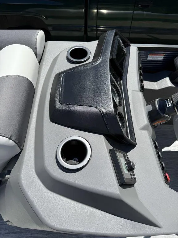 Slide: The Image of 2026 Bennington S Quad Bench 22 SSR dashboard with cup holders and controls. - 17