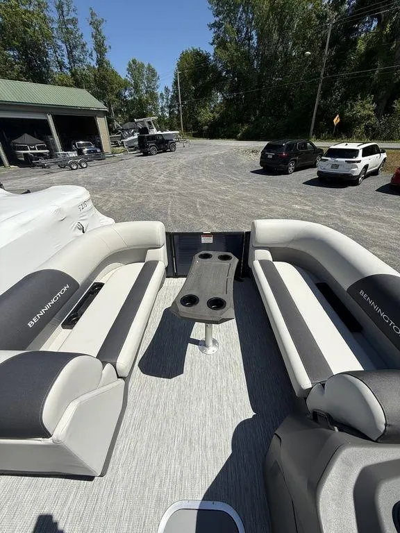 Slide: The Image of 2026 Bennington S Quad Bench 22 SSR pontoon boat interior with seating and table. - 22