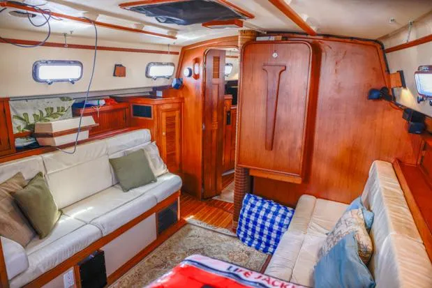 Slide: The Image of Interior of 1998 Island Packet 40 sailboat with cozy seating and wooden finishes. - 16