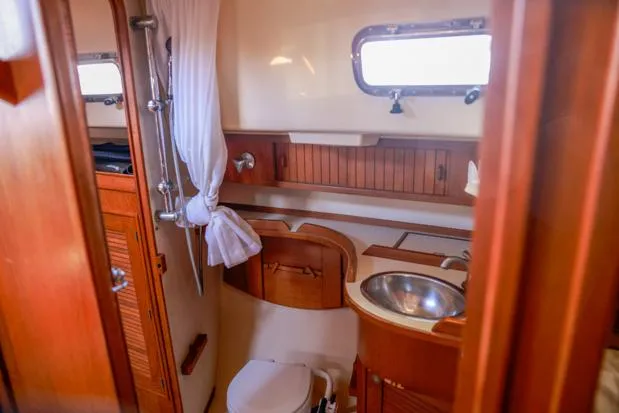 Slide: The Image of 1998 Island Packet 40 yacht bathroom with wooden cabinetry and stainless steel sink. - 18