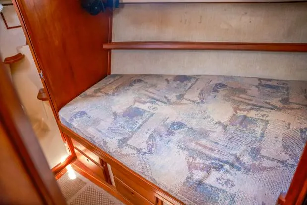 Slide: The Image of 1998 Island Packet 40 interior cabin with patterned bedding and wooden storage. - 23