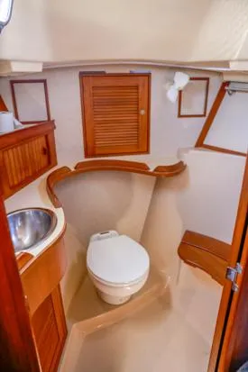 Slide: The Image of 1998 Island Packet 40 yacht bathroom with wooden accents and stainless steel sink. - 27