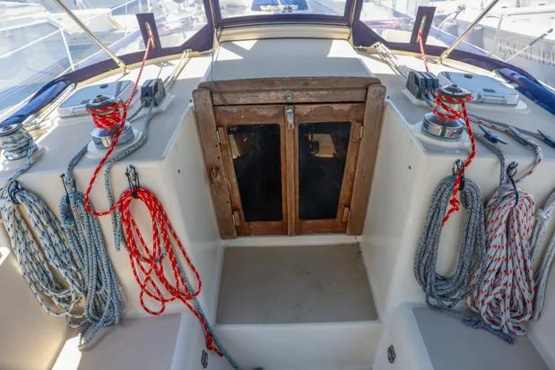 Slide: The Image of 1998 Island Packet 40 sailboat cockpit with ropes and wooden hatch. - 8