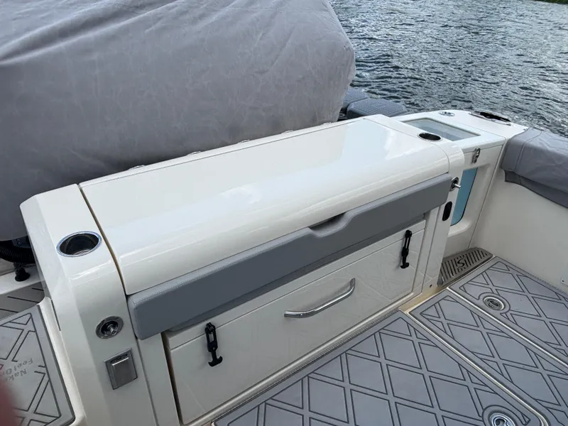 Slide: The Image of 2024 Scout 377 LXF boat interior with storage compartments and cup holders. - 17