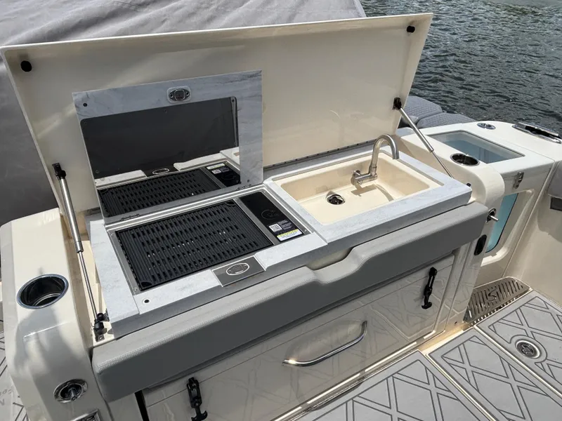 Slide: The Image of 2024 Scout 377 LXF boat with outdoor sink and grill setup. - 18