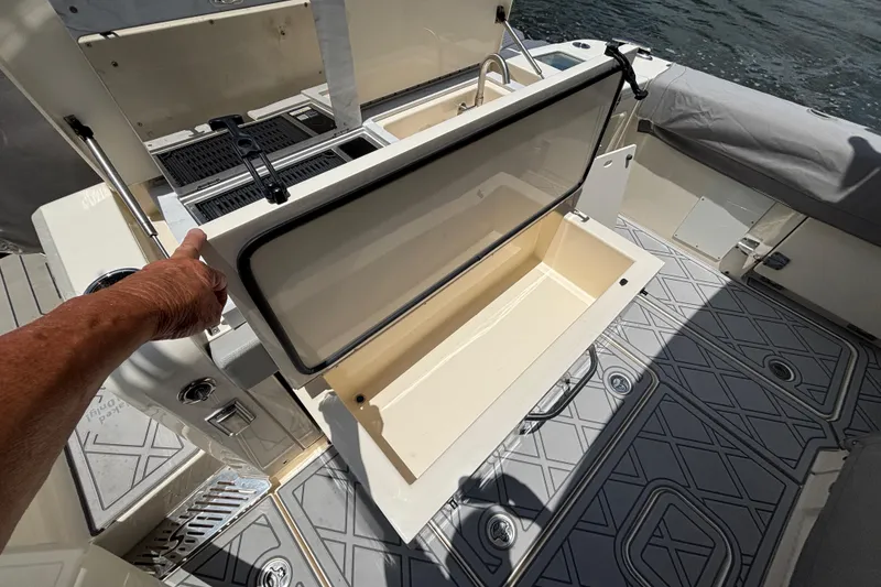 Slide: The Image of 2024 Scout 377 LXF boat interior with open storage compartment and deck view. - 20
