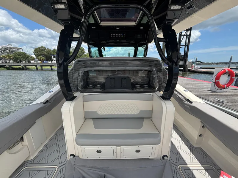 Slide: The Image of 2024 Scout 377 LXF boat interior with seating, docked by the water. - 22