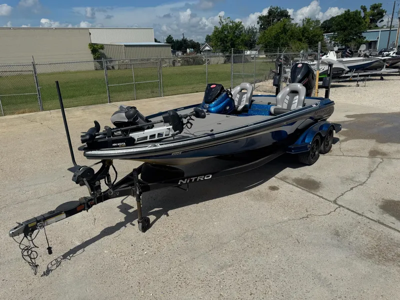 Slide: The Image of 2019 Nitro Z20 fishing boat on trailer, parked outdoors under a clear sky. - 6