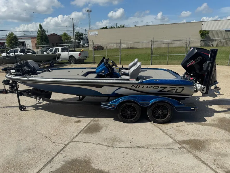 Slide: The Image of 2019 Nitro Z20 boat on trailer, parked outdoors under a partly cloudy sky. - 7