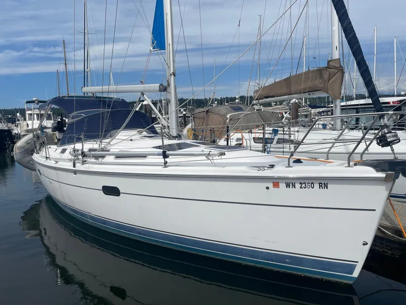 Slide: The Image of 2004 Hunter 36 sailboat docked at marina, featuring sleek white hull and blue sail cover. - 1