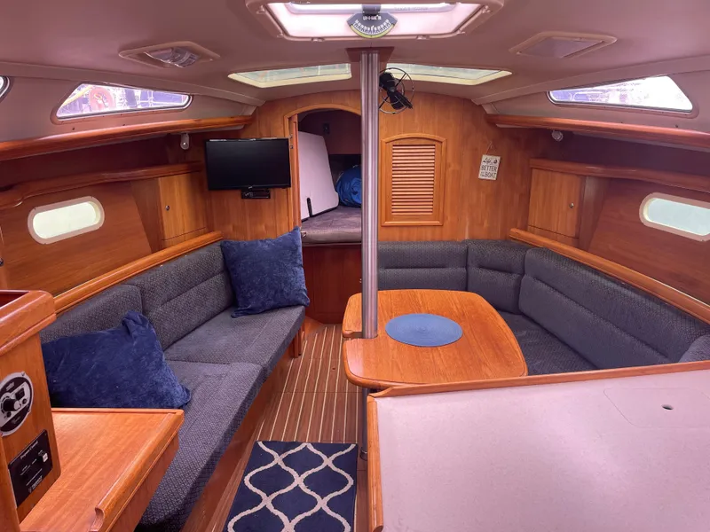 Slide: The Image of Interior of a 2004 Hunter 36 sailboat with cozy seating and wooden finishes. - 11