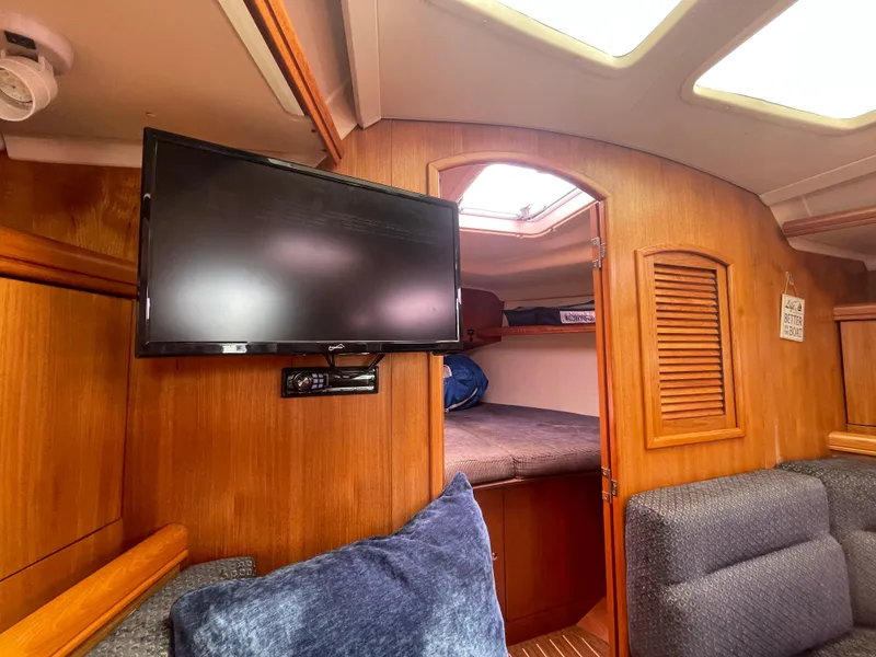 Slide: The Image of Interior of 2004 Hunter 36 sailboat with TV, cozy seating, and wooden cabinetry. - 12