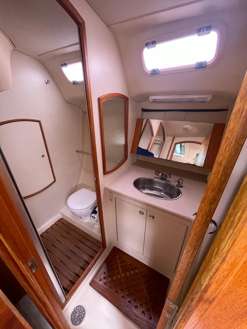 Slide: The Image of Compact bathroom in a 2004 Hunter 36 yacht with sink, toilet, and wooden accents. - 15