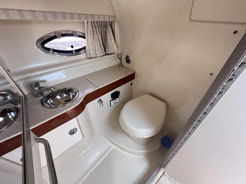 Slide: The Image of 2007 Formula 310 Sun Sport boat bathroom with sink, toilet, and porthole window. - 27