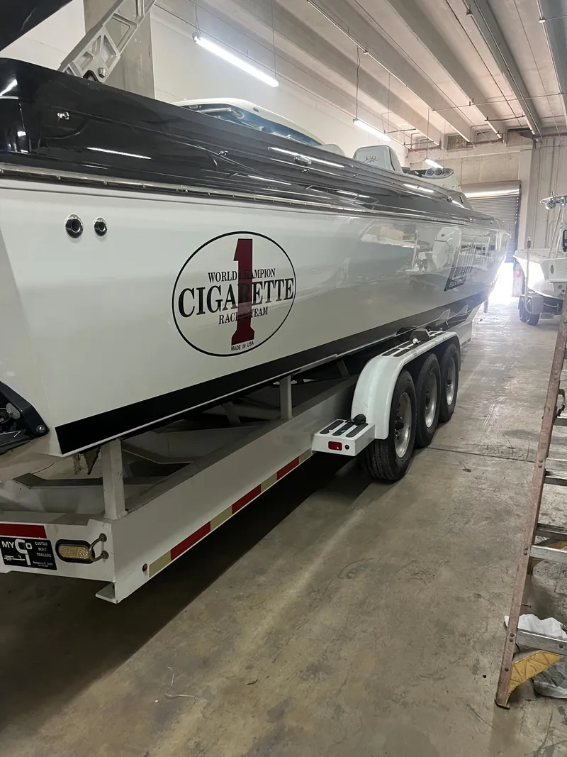 The Image of 2012 Cigarette 50' Marauder AMG boat on trailer in indoor storage facility. - 0