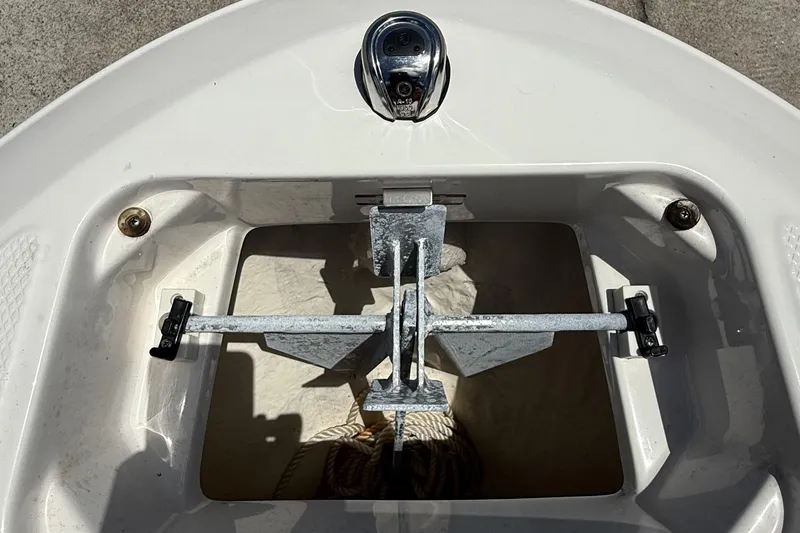 Slide: The Image of Anchor compartment of 2022 Chaparral 21 SSi OB boat, featuring metal anchor and rope. - 19
