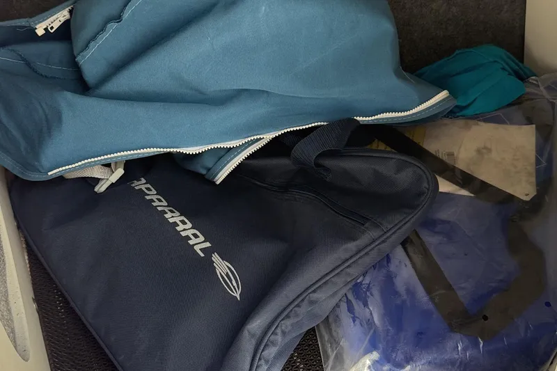 Slide: The Image of Storage compartment with Chaparral 21 SSi OB accessories, including blue and navy bags, 2022 model. - 26