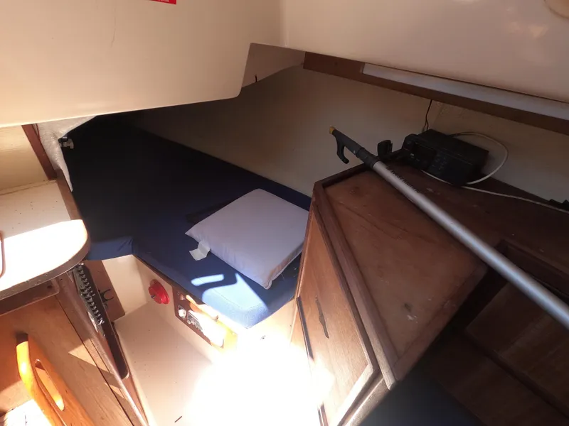 Slide: The Image of Interior cabin of a 1979 Hunter 30 sailboat with a bed and wooden storage. - 11