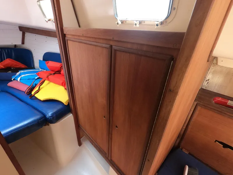 Slide: The Image of Interior of 1979 Hunter 30 sailboat with wooden cabinets and colorful life jackets. - 16