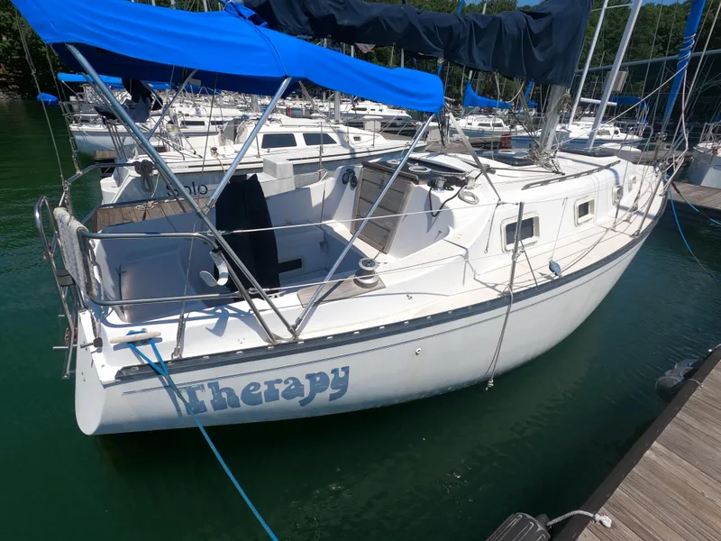 Slide: The Image of 1979 Hunter 30 sailboat named "Therapy" docked at marina with blue canopy. - 3