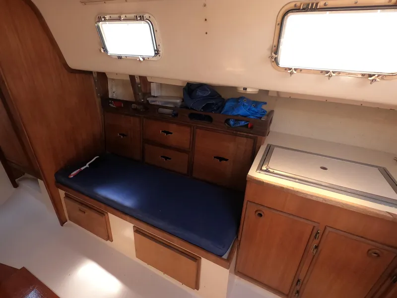 Slide: The Image of Interior of 1979 Hunter 30 sailboat with wooden cabinetry and blue cushioned seating. - 9