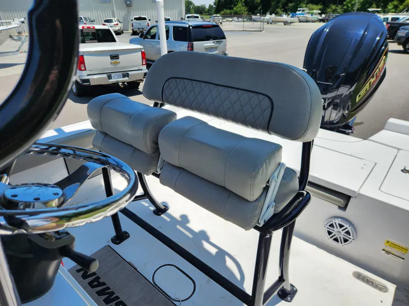 Slide: The Image of 2023 Sportsman Masters 227 Bay Boat helm with cushioned seating and steering wheel. - 10