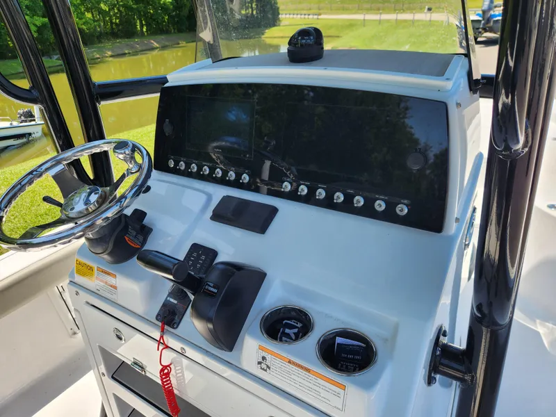 Slide: The Image of 2023 Sportsman Masters 227 Bay Boat dashboard with steering wheel and controls. - 8