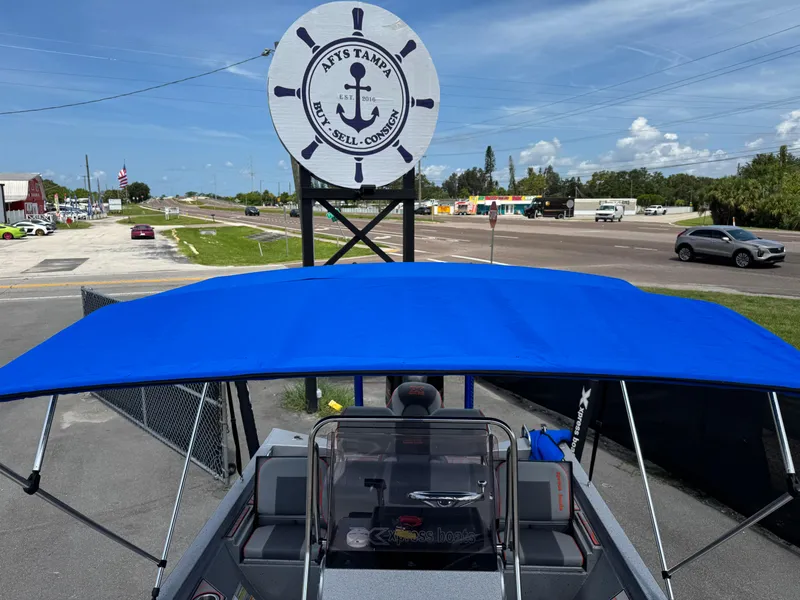 Slide: The Image of 2022 Xpress H24B boat interior with custom flooring and seating, docked outdoors. - 36