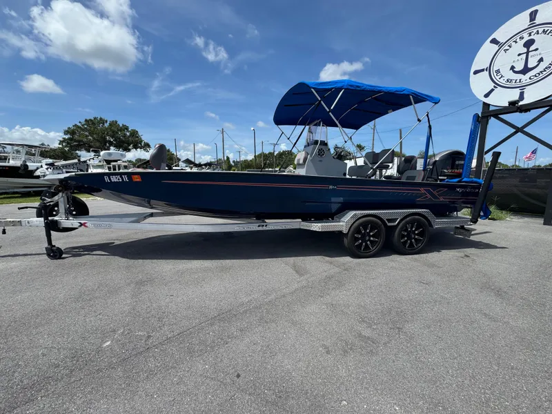 Slide: The Image of 2022 Xpress H24B boat with blue canopy on a trailer, featuring Yamaha engine. - 4