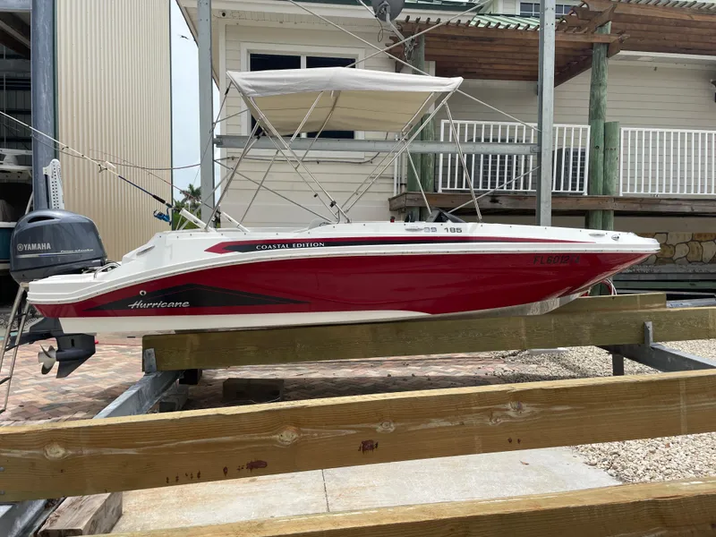 The Image of 2021 Hurricane SunDeck Sport 185 OB boat with Yamaha engine, docked on wooden supports. - 0