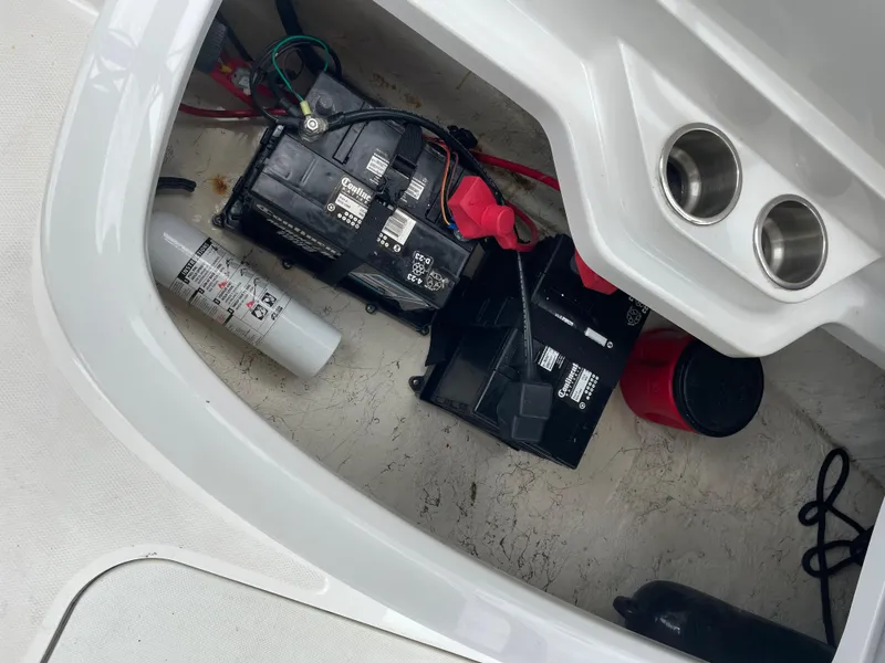 Slide: The Image of 2021 Hurricane SunDeck Sport 185 OB boat battery compartment with fire extinguisher and wiring. - 18