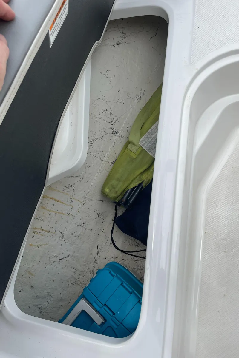 Slide: The Image of Storage compartment in 2021 Hurricane SunDeck Sport 185 OB boat with gear and cooler. - 19