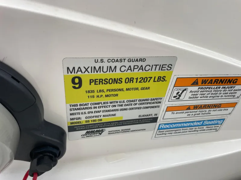 Slide: The Image of 2021 Hurricane SunDeck Sport 185 OB capacity label, 9 persons or 1207 lbs, safety warnings. - 24