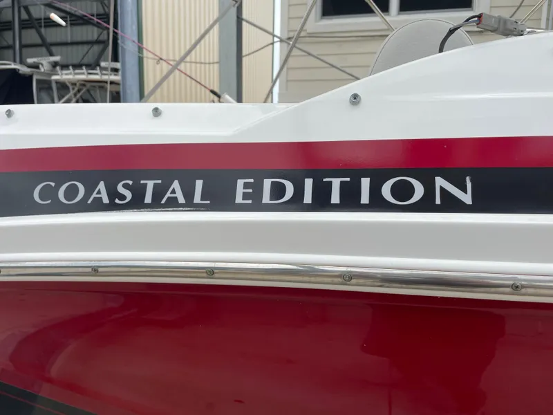 Slide: The Image of 2021 Hurricane SunDeck Sport 185 OB, Coastal Edition boat detail with red and white design. - 26