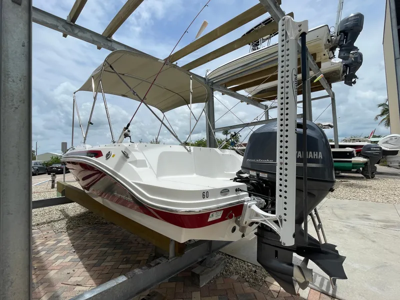 Slide: The Image of 2021 Hurricane SunDeck Sport 185 OB boat with Yamaha outboard motor on a lift. - 4