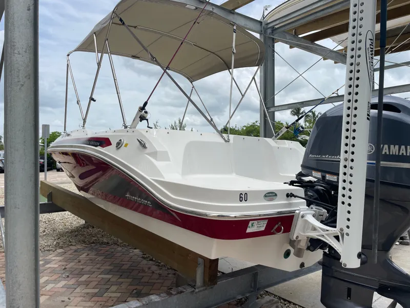 Slide: The Image of 2021 Hurricane SunDeck Sport 185 OB boat with Yamaha outboard motor, docked under canopy. - 5
