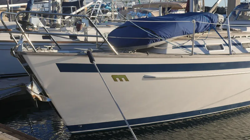 Slide: The Image of Sailboat Malo 43, 2001 model, docked at marina with blue cover. - 2