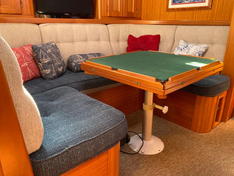 Slide: The Image of Cozy Malo 43 yacht interior with cushioned seating and a wooden table, 2001 model. - 22