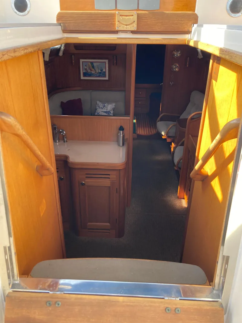 Slide: The Image of Interior view of a 2001 Malo 43 sailboat, featuring wooden cabinetry and seating area. - 4