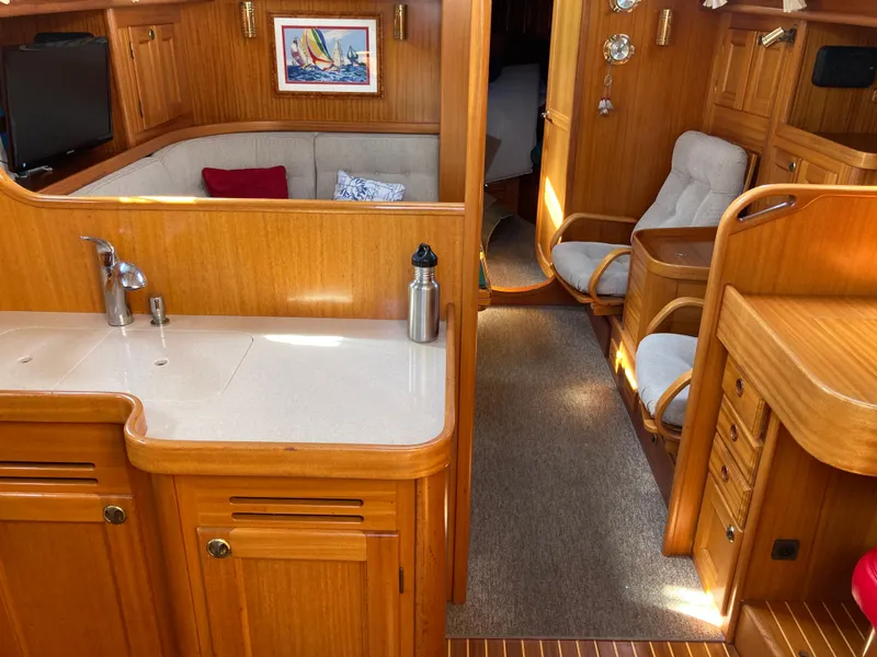 Slide: The Image of Interior of 2001 Malo 43 yacht with wooden finish, cozy seating, and kitchenette. - 5