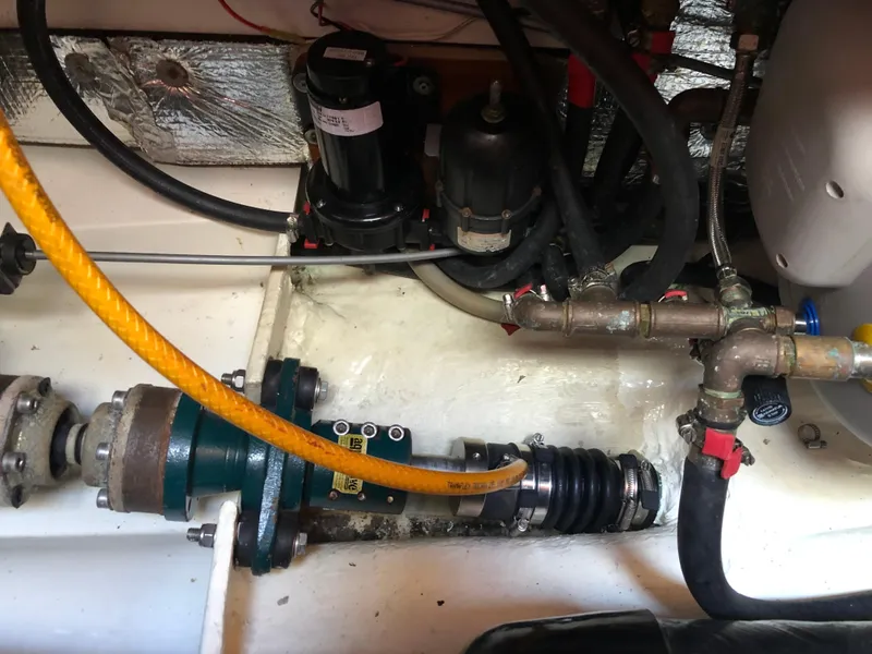 Slide: The Image of Engine compartment of a 2001 Malo 43 sailboat, showing mechanical components and hoses. - 53